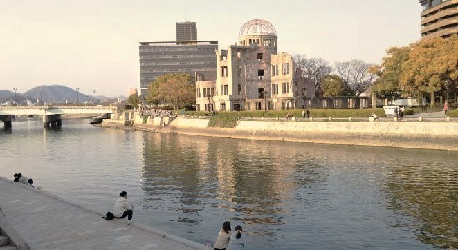 広島・平和記念公園の川沿いでくつろぐ人々の風景