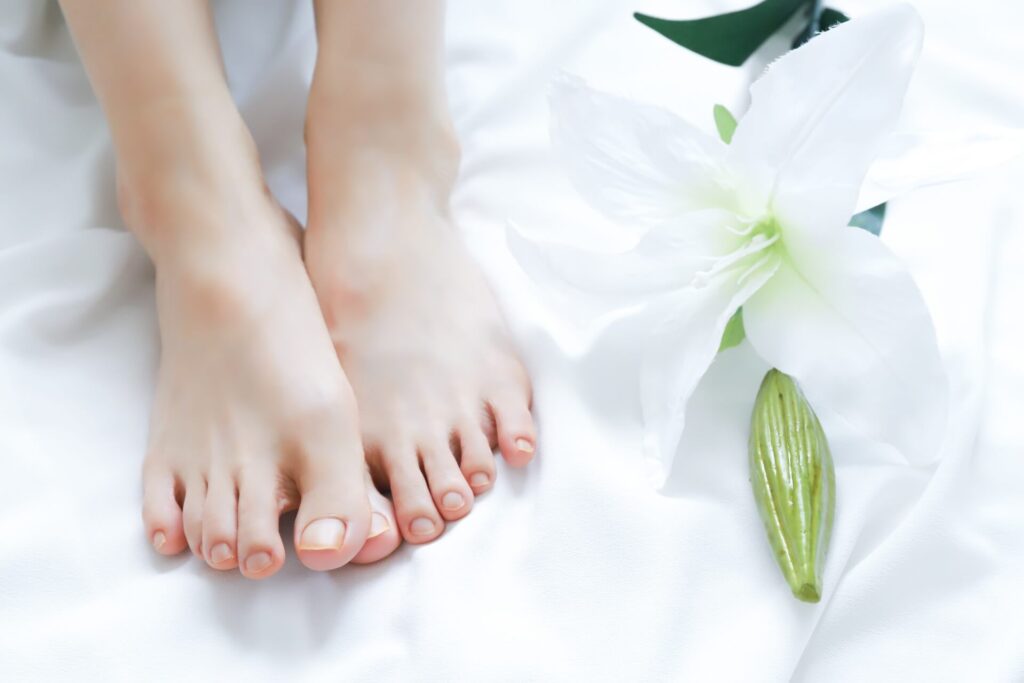 Bare feet of a woman on a neutral background for foot care context
